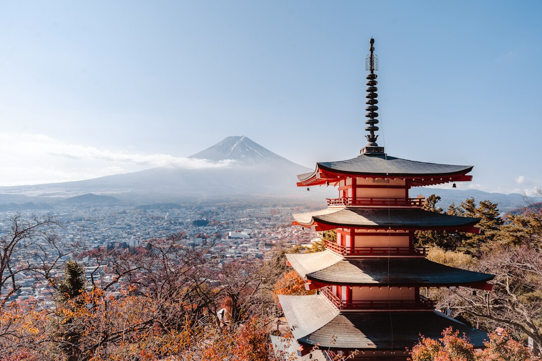 Traditional Japanese pagoda surrounded by red autumn leaves